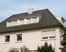 Wohn- und Geschäftshaus in Stuttgart-Ost mit anthrazitfarbenem Dach und Schleppgaube