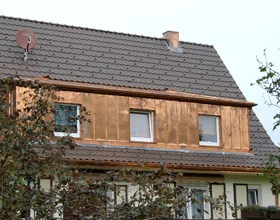 Wohnhaus in Karlsruhe mit dunklem Ziegeldach und holzverkleideter Gaube